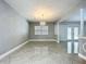 The living area boasts gray walls, tiled floors, and a modern chandelier near a window, with an open view to the pool at 7609 Barry Rd, Tampa, FL 33615