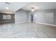Expansive open-concept living space with a view of the adjoining room, tiled floors, and neutral gray paint at 7609 Barry Rd, Tampa, FL 33615