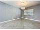 Bright living space with neutral gray walls and matching floors, featuring a modern chandelier and a window at 7609 Barry Rd, Tampa, FL 33615