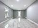 Light-filled living room with gray walls, tile floors, and a window for natural light at 7609 Barry Rd, Tampa, FL 33615