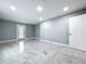 Light-filled living room with gray walls, tile floors, and a door leading to the outside at 7609 Barry Rd, Tampa, FL 33615