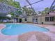 Inviting pool area featuring a screened enclosure, patio, and access to the home's exterior at 7609 Barry Rd, Tampa, FL 33615
