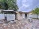 A spacious shed in the backyard, featuring brick-paved patio and surrounding white picket fence at 7609 Barry Rd, Tampa, FL 33615