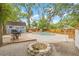 Expansive backyard featuring a pool, spa, outdoor kitchen area, and fire pit at 7708 N Arden Ave, Tampa, FL 33604