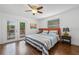 Bright bedroom with a queen-size bed, ceiling fan, and access to an outdoor deck at 7708 N Arden Ave, Tampa, FL 33604