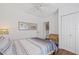 Cozy bedroom features neutral walls, hardwood flooring, and a comfortable seating area at 7708 N Arden Ave, Tampa, FL 33604