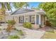 Charming blue home with landscaped yard, brick walkway, and inviting covered front porch at 7708 N Arden Ave, Tampa, FL 33604