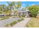 Charming blue home with landscaped yard, brick walkway, and inviting covered front porch at 7708 N Arden Ave, Tampa, FL 33604