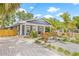 Charming blue home with landscaped yard, brick walkway, and inviting covered front porch at 7708 N Arden Ave, Tampa, FL 33604
