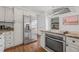 Updated kitchen with stainless steel appliances, granite countertops, and white cabinetry at 7708 N Arden Ave, Tampa, FL 33604