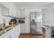 Bright kitchen with stainless steel refrigerator, white cabinets, and granite countertops at 7708 N Arden Ave, Tampa, FL 33604