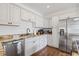 Contemporary kitchen showcasing stainless steel appliances, granite countertops, and classic white cabinets at 7708 N Arden Ave, Tampa, FL 33604