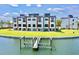 Modern townhome exterior featuring multiple stories, balconies, and private boat dock, ideal for waterfront living at 772 Gran Kaymen Way, Apollo Beach, FL 33572