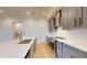 Modern kitchen with stainless steel appliances, gray cabinets, quartz countertops, and stylish finishes at 772 Gran Kaymen Way, Apollo Beach, FL 33572