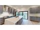 Modern kitchen with stainless steel appliances, gray cabinets, quartz countertops, and a view of the water at 772 Gran Kaymen Way, Apollo Beach, FL 33572