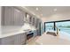 Modern kitchen featuring stainless steel appliances, stylish gray cabinetry, and quartz countertops at 772 Gran Kaymen Way, Apollo Beach, FL 33572