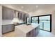 Modern kitchen with stainless steel appliances, sleek gray cabinets, quartz countertops, and water view at 772 Gran Kaymen Way, Apollo Beach, FL 33572