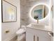 Elegant powder room with marble accent wall, round mirror, and modern fixtures at 772 Gran Kaymen Way, Apollo Beach, FL 33572