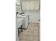 Functional laundry room with white washer and dryer, tile floor, and storage cabinets at 8054 Spring Hill Dr, Spring Hill, FL 34606