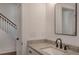 Bright bathroom with granite countertop, square mirror, and adjacent staircase with white railing at 807 E Ida St # 1, Tampa, FL 33603
