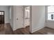 Hallway view of a bathroom showcasing a white door, hardwood floors, and window at 807 E Ida St # 1, Tampa, FL 33603
