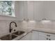 Close-up of a kitchen with a double sink, granite countertops, and white cabinets with recessed lighting at 807 E Ida St # 1, Tampa, FL 33603