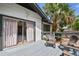 A view of backyard deck with outdoor seating area and large sliding glass door to home at 811 E Flora St, Tampa, FL 33604