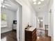Hallway view with hardwood floors, leading to a bright bedroom and a cozy bathroom with a tiled floor at 811 E Flora St, Tampa, FL 33604