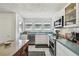 Well-lit kitchen with stainless steel appliances, a large window and white cabinets at 811 E Flora St, Tampa, FL 33604