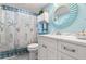 Nautical-themed bathroom featuring white vanity, seashell decorations, and a shower with a starfish-patterned curtain at 8141 Aquila St # 346, Port Richey, FL 34668