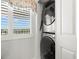 Efficient laundry closet with a stackable washer and dryer, along with functional window blinds at 8141 Aquila St # 346, Port Richey, FL 34668