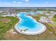 Aerial view of a clear blue community lagoon, with docks and kayaks, surrounded by homes and lush landscaping at 8919 Drummer Plank Dr, Wesley Chapel, FL 33545