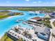 Aerial view of a community lagoon with a swim-up bar, lounge chairs, cabanas, palm trees, and white sand beaches at 8919 Drummer Plank Dr, Wesley Chapel, FL 33545