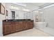 Bathroom featuring a double sink vanity, freestanding tub, and glass-enclosed shower with marble-look tile at 8919 Drummer Plank Dr, Wesley Chapel, FL 33545