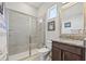 This bathroom features tile shower with glass door, vanity and granite countertop at 8919 Drummer Plank Dr, Wesley Chapel, FL 33545
