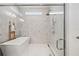 Modern bathroom featuring a soaking tub and glass-enclosed shower with sleek fixtures and marble-look tile at 8919 Drummer Plank Dr, Wesley Chapel, FL 33545