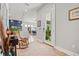 A large rug welcomes guests into this well lit entryway with dining room and kitchen views at 8919 Drummer Plank Dr, Wesley Chapel, FL 33545