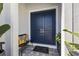 Stylish double front door with decorative bench and accent pillows, creating a welcoming entry at 8919 Drummer Plank Dr, Wesley Chapel, FL 33545