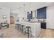 Bright kitchen featuring an eat-in kitchen island with three stools and sleek, pendant lighting and wood-look floors at 8919 Drummer Plank Dr, Wesley Chapel, FL 33545