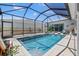 Sparkling pool in screened enclosure, surrounded by lounge seating and lush landscaping at 8919 Drummer Plank Dr, Wesley Chapel, FL 33545