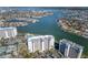 Elevated view of the condo building and surrounding waterfront featuring a pool and ample parking at 9525 Blind Pass Rd # 508, St Pete Beach, FL 33706