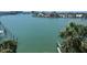 Scenic waterfront view from the balcony, featuring docks and lush palm trees at 9525 Blind Pass Rd # 508, St Pete Beach, FL 33706