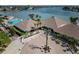Elegant clubhouse entrance with lush landscaping, palm trees, and pool area in the background at 9525 Blind Pass Rd # 508, St Pete Beach, FL 33706