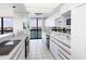 The kitchen is styled with white cabinetry and modern appliances with natural light at 9525 Blind Pass Rd # 508, St Pete Beach, FL 33706