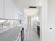 Modern galley-style kitchen with white cabinetry, light counters, and tiled floor at 9525 Blind Pass Rd # 508, St Pete Beach, FL 33706