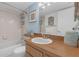 Bright bathroom featuring a shower-tub combo with updated fixtures and light wood vanity at 9815 Harrell Ave # 502, Treasure Island, FL 33706