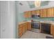 Well-lit kitchen features stainless steel appliances and natural wood cabinetry at 9815 Harrell Ave # 502, Treasure Island, FL 33706