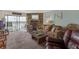 Cozy living room featuring a stone fireplace, plush sofa, and balcony access with scenic water views at 9815 Harrell Ave # 502, Treasure Island, FL 33706