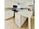 Modern kitchen featuring white cabinets, stainless steel appliances, and a center island with quartz countertop at 1002 E North Bay St, Tampa, FL 33603