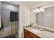 Cozy bathroom featuring single vanity with granite countertop and tiled shower with curtain at 10404 Scarlet Chase Dr, Riverview, FL 33569